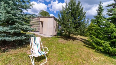 Příjemná venkovská zahrada s rekreačním karavanem a terasou.